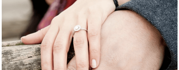 Holding hands showing engagement ring